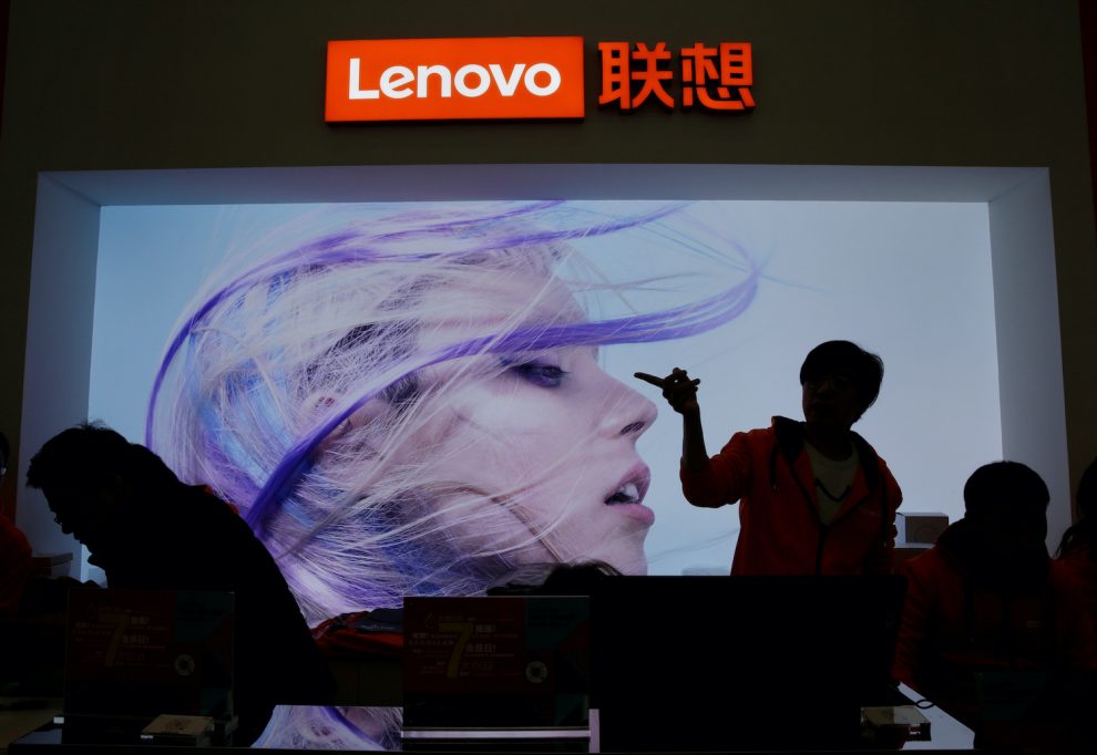 An-employee-gestures-next-to-a-Lenovo-lo