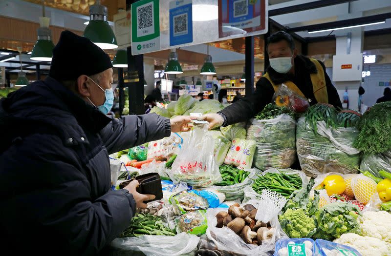 People wearing masks shop in Beijing. Rising food prices pushed up inflation in September at the fastest pace since April 2020, official data showed.