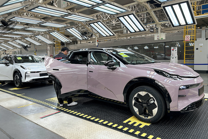 Staff work on an assembly line manufacturing Zeekr X trial production models, at Geely's plant in Chengdu, Sichuan province, China
