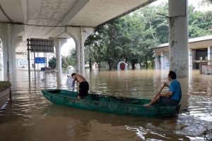 People travel through a flooded road with a boat following heavy rainfall in Liuzhou, Guangxi Zhuang Autonomous Region, China