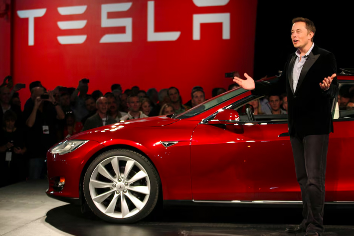 Tesla Motors CEO Elon Musk speaks next to the company's newest Model S during the Model S Beta Event held at the Tesla factory.