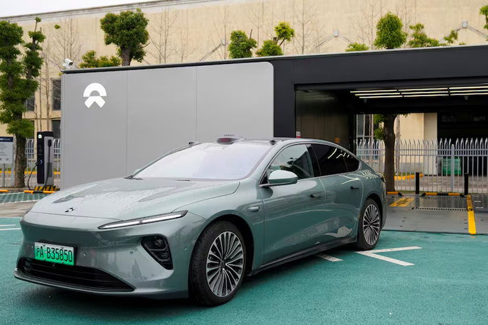 A staff member of Chinese electric vehicle (EV) maker Nio drives a Nio car