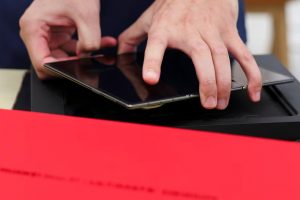 A staff member prepares a Huawei Mate XT for a customer as the tri-foldable smartphone goes on sale at a Huawei flagship store in Beijing, China.