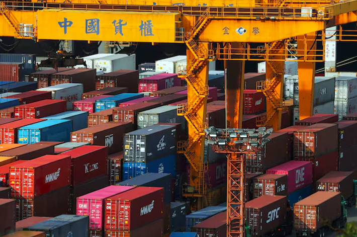 Trucks wait to be loaded on with containers at a port in Keelung, Taiwan.