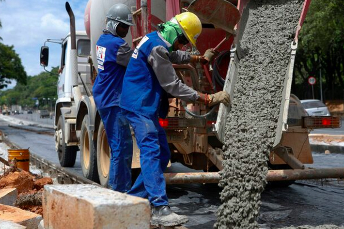 Workers pour cement to construct a new bus lane. Because of the complexities of producing cement,