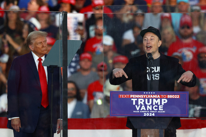 Trump listens as Tesla CEO Elon Musk speaks at a rally in July in Pennsylvania, October 5, 2024