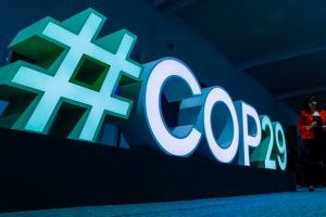 A woman passes by a #COP29 sign during the United Nations climate change conference COP29 in Baku,