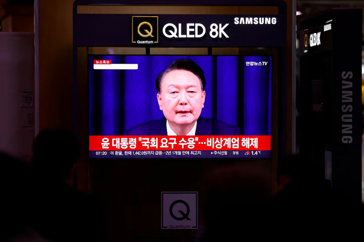 People watch a TV screen broadcasting a news report on South Korean President Yoon Suk Yeol's declaration of martial law and the following announcement that he will lift the martial law, after parliamentary vote, at a railway station in Seoul, South Korea.