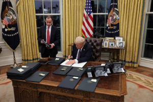 US President Donald Trump signs documents as he issues executive orders and pardons for January 6 defendants in the Oval Office at the White House on Inauguration Day in Washington, US